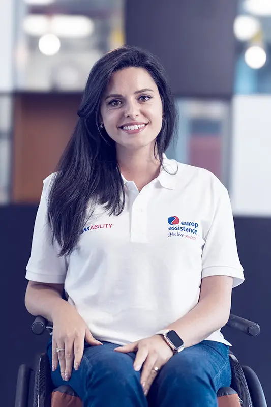 Woman in wheelchair sits and looks at the camera